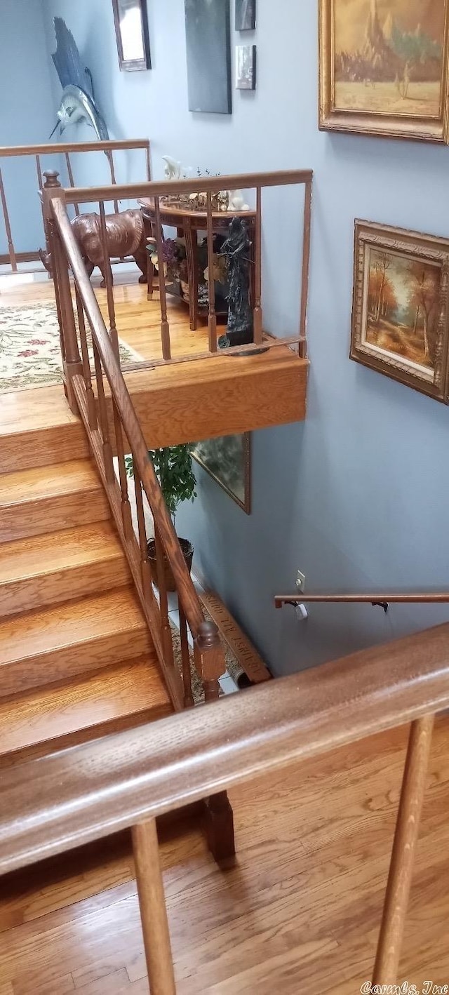 staircase with hardwood / wood-style floors