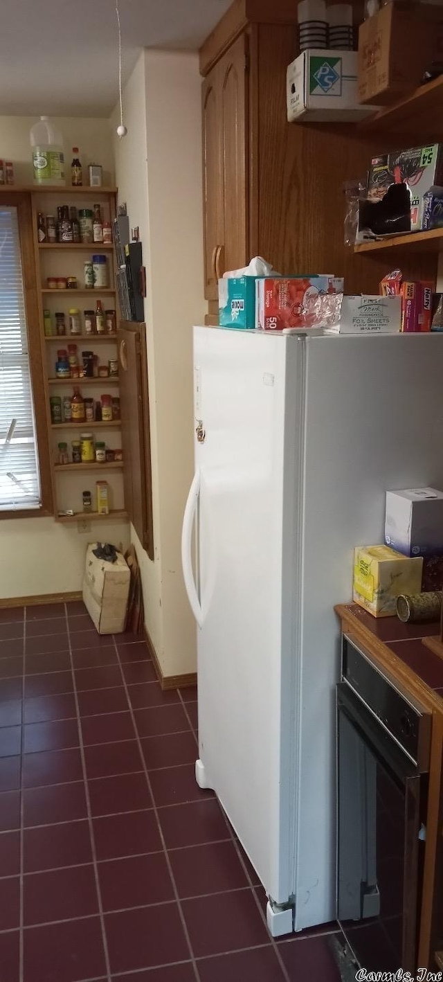 kitchen featuring dark tile patterned floors and white refrigerator