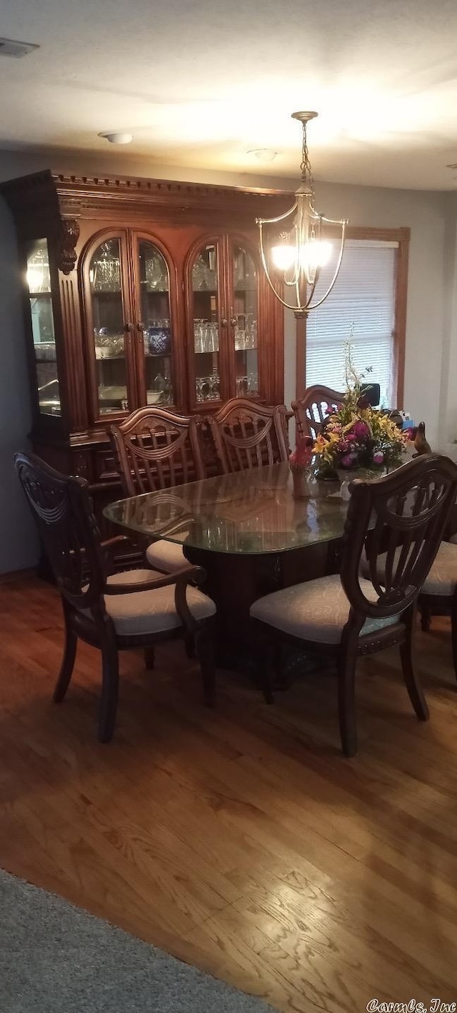 dining area with a chandelier and dark wood-type flooring