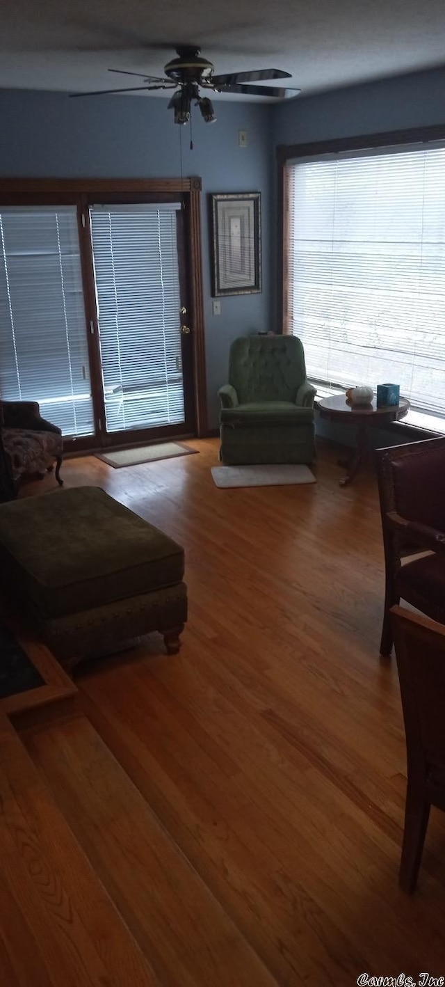 living room featuring wood-type flooring and ceiling fan