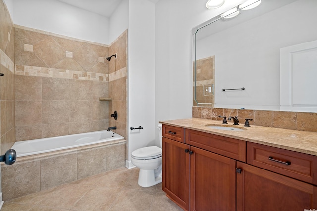 full bathroom with tile floors, toilet, vanity, and tiled shower / bath