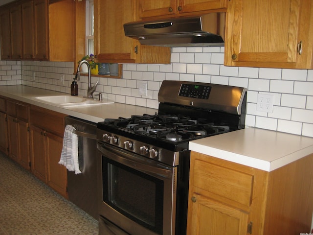 kitchen featuring appliances with stainless steel finishes, tasteful backsplash, and sink