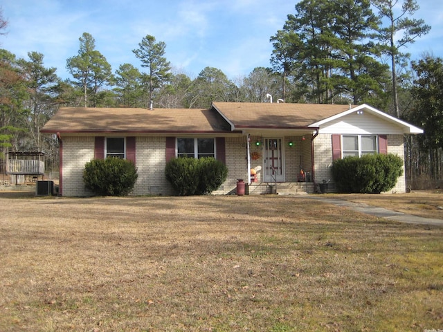 ranch-style home with a front lawn and central air condition unit