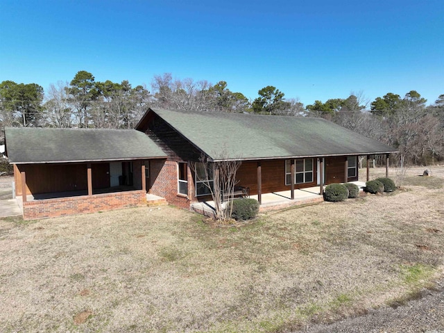 back of property featuring a patio area and a yard