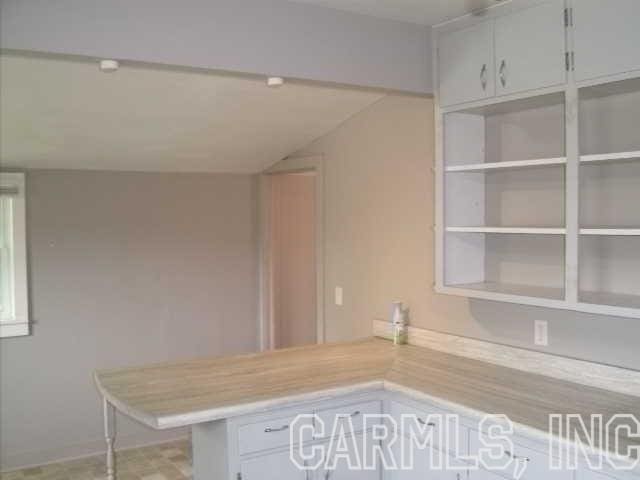 kitchen featuring white cabinetry and vaulted ceiling