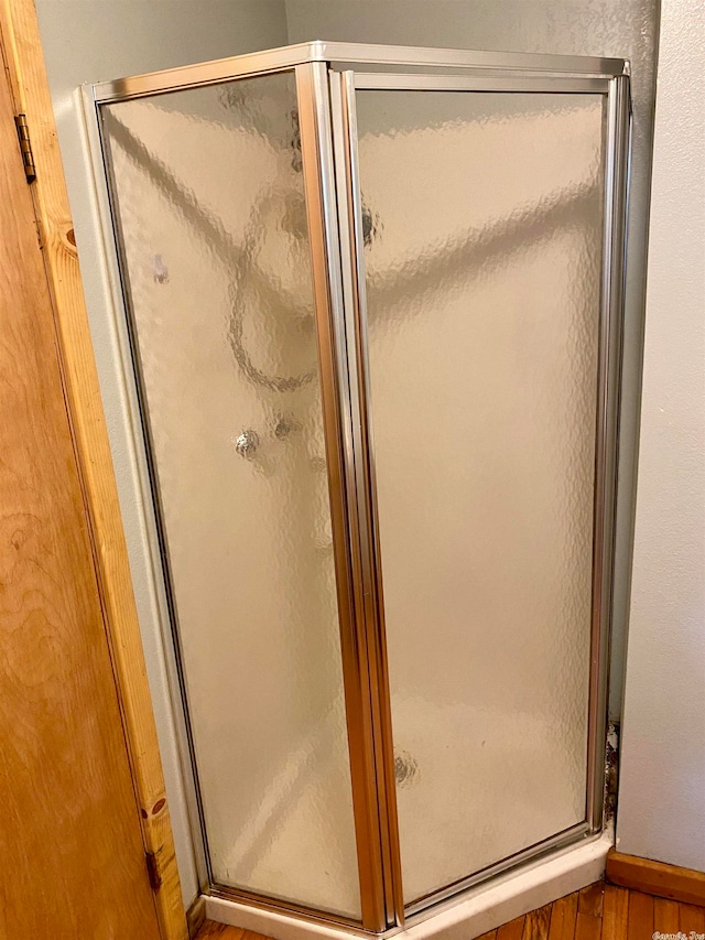 bathroom featuring wood-type flooring and a shower with door