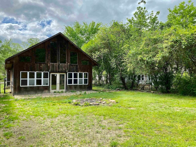 rear view of house with french doors and a lawn