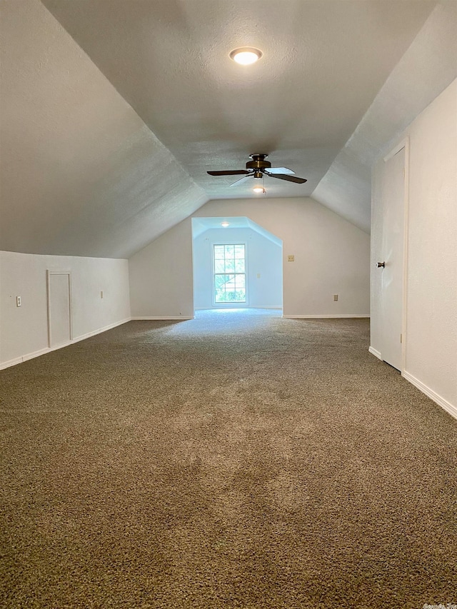 additional living space with ceiling fan, carpet, lofted ceiling, and a textured ceiling