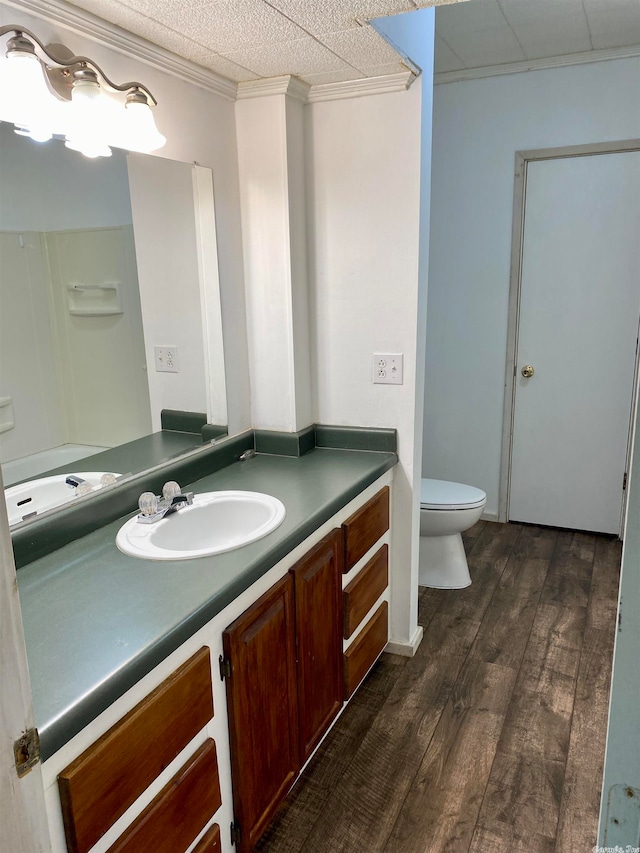 bathroom featuring toilet, a textured ceiling, ornamental molding, vanity, and hardwood / wood-style floors