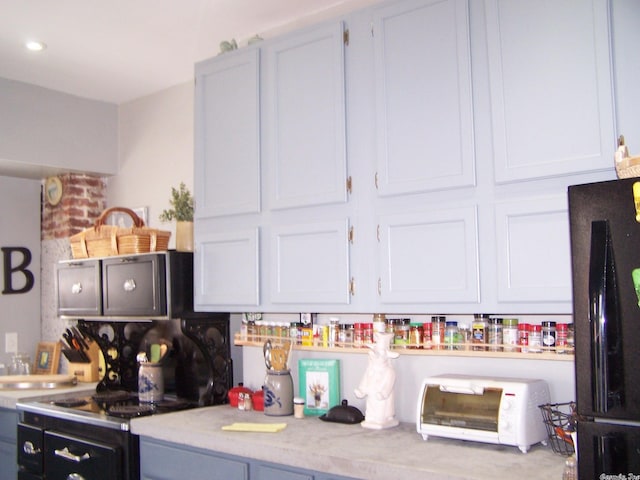 kitchen featuring white cabinetry and black refrigerator