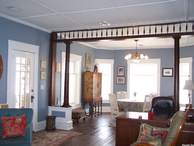 living room featuring a chandelier, dark wood-type flooring, and ornamental molding