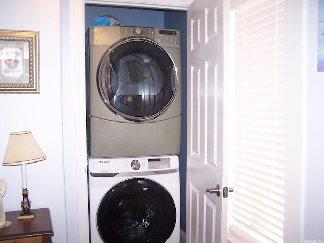 clothes washing area with stacked washing maching and dryer