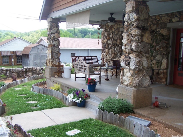 view of terrace featuring an outdoor structure, an outdoor living space, and ceiling fan