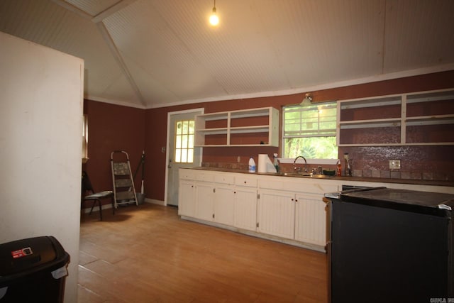 kitchen featuring ornamental molding, sink, lofted ceiling, light wood-type flooring, and white cabinets