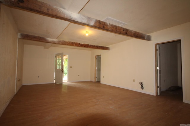 empty room featuring beamed ceiling and wood-type flooring