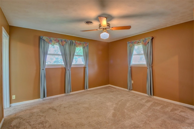 carpeted empty room with plenty of natural light and ceiling fan