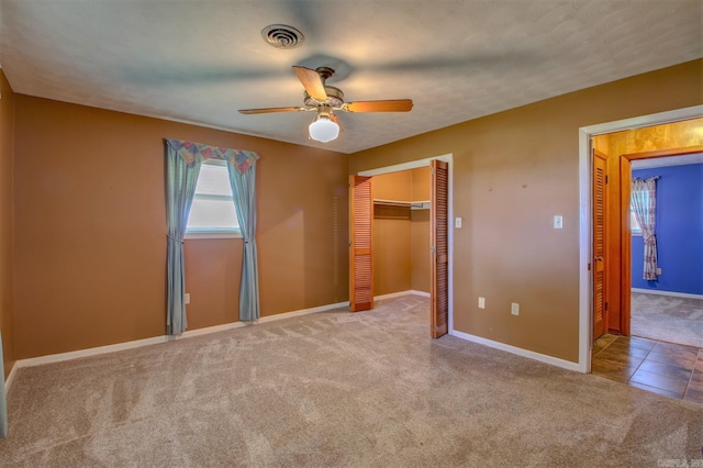 unfurnished bedroom with ceiling fan, a closet, and light colored carpet