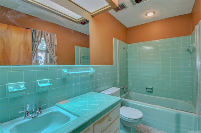 full bathroom with tile flooring, tiled shower / bath, and tile walls