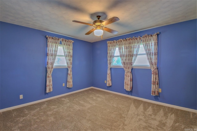 carpeted spare room with ceiling fan