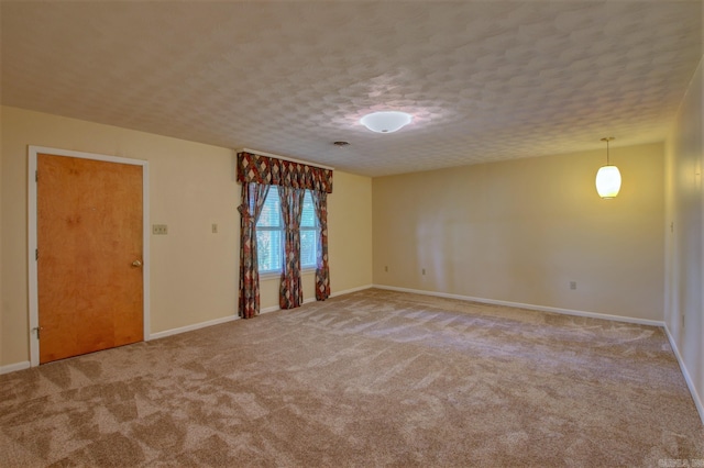 empty room featuring light colored carpet and a textured ceiling