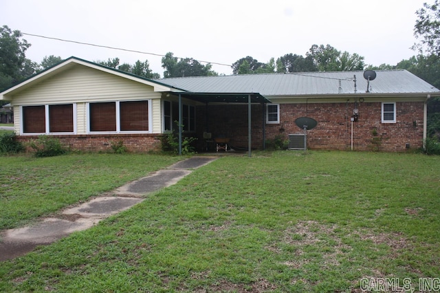 ranch-style house featuring central air condition unit and a front lawn