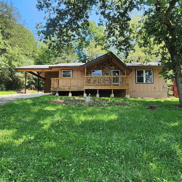 view of front of house with a deck, a front lawn, and a carport