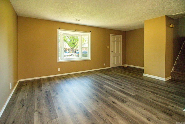 empty room featuring dark hardwood / wood-style flooring and a textured ceiling