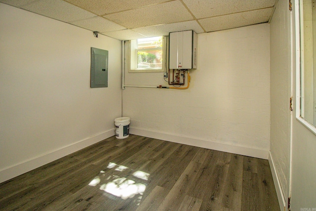 basement featuring water heater, dark hardwood / wood-style flooring, and a paneled ceiling