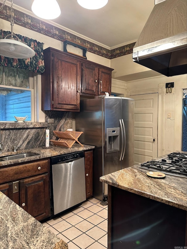 kitchen featuring tasteful backsplash, dark brown cabinets, light tile floors, stainless steel appliances, and wall chimney exhaust hood