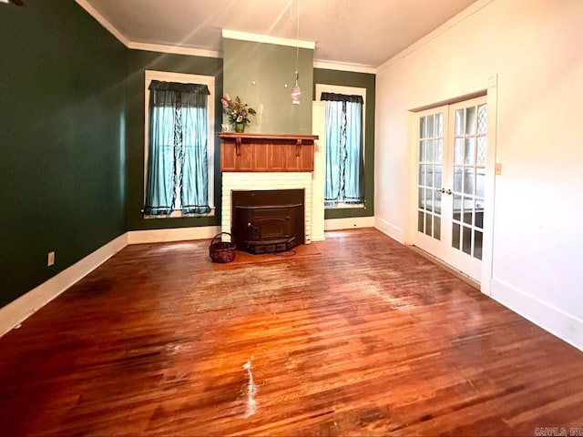 unfurnished living room with a wood stove, wood-type flooring, a brick fireplace, ornamental molding, and french doors