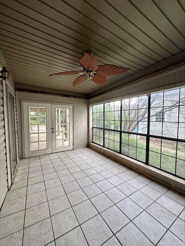 unfurnished sunroom with ceiling fan, wooden ceiling, and french doors