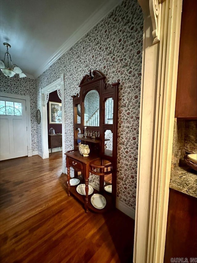 hall featuring a chandelier, ornamental molding, and dark hardwood / wood-style floors