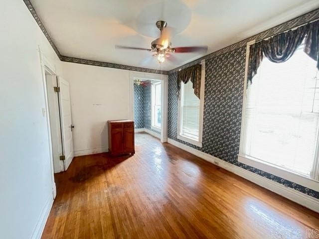 empty room with dark hardwood / wood-style floors and ceiling fan