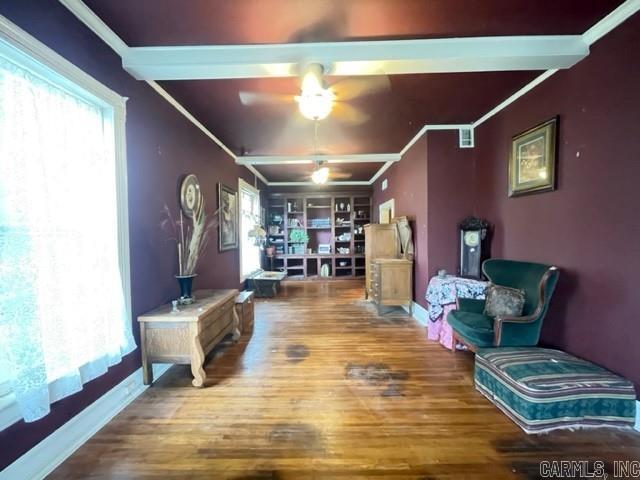 living room featuring crown molding, wood-type flooring, and ceiling fan