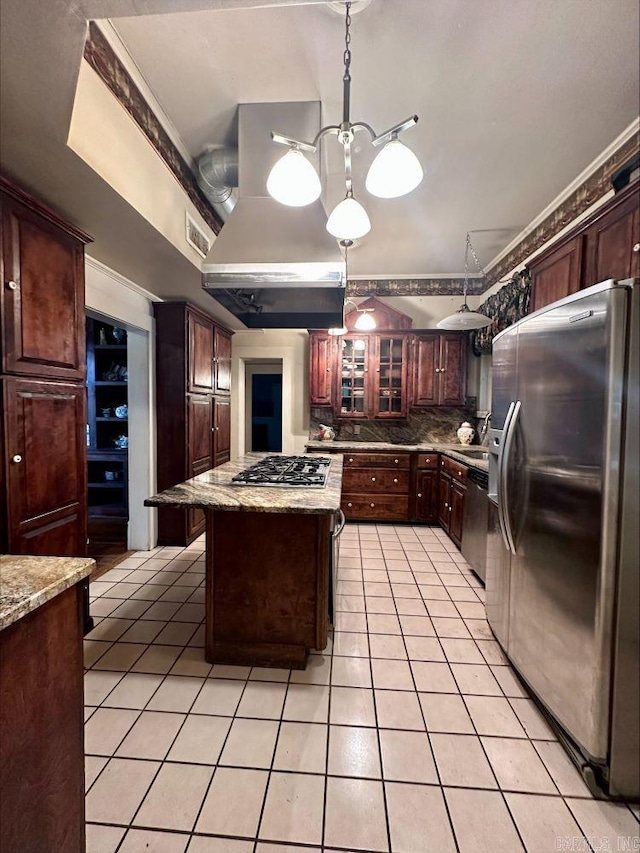 kitchen with hanging light fixtures, a notable chandelier, appliances with stainless steel finishes, a kitchen island, and tasteful backsplash