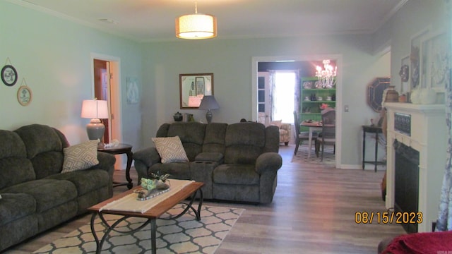 living room with ornamental molding, a tiled fireplace, and hardwood / wood-style floors