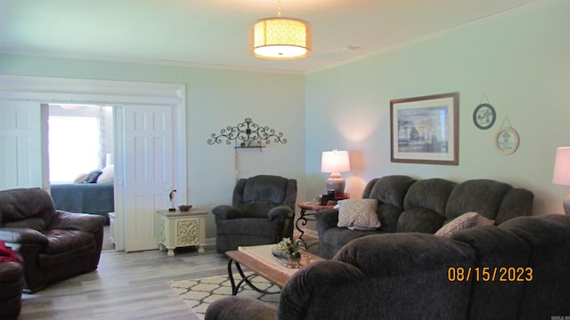 living room with ornamental molding and light wood-type flooring