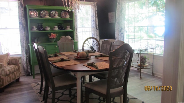 dining area featuring an inviting chandelier, dark hardwood / wood-style floors, and a healthy amount of sunlight