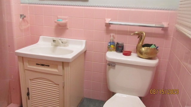 bathroom with backsplash, toilet, vanity, and tile walls