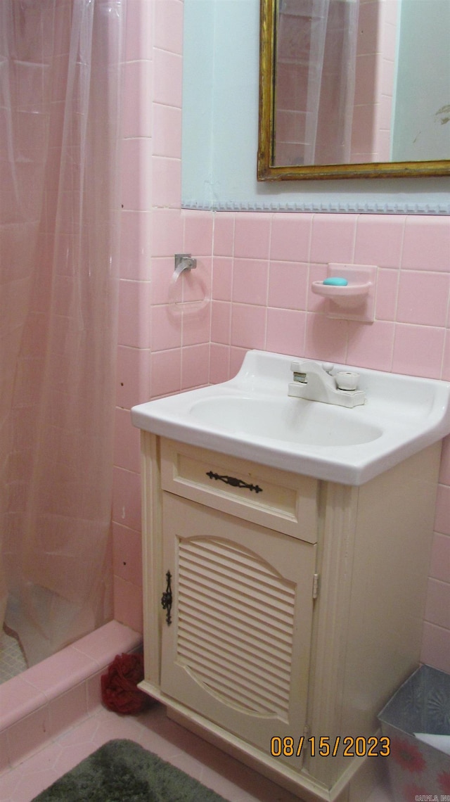 bathroom featuring tile walls, vanity, backsplash, and a shower with shower curtain