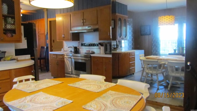 kitchen with an inviting chandelier, stainless steel electric stove, and pendant lighting