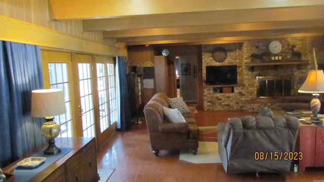 living room featuring brick wall, a brick fireplace, french doors, and beam ceiling