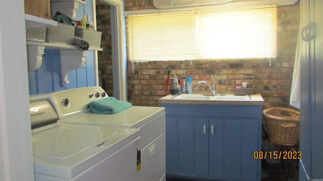 laundry area with independent washer and dryer, sink, and cabinets