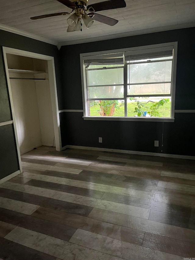 unfurnished bedroom with a closet, multiple windows, dark hardwood / wood-style floors, and ceiling fan