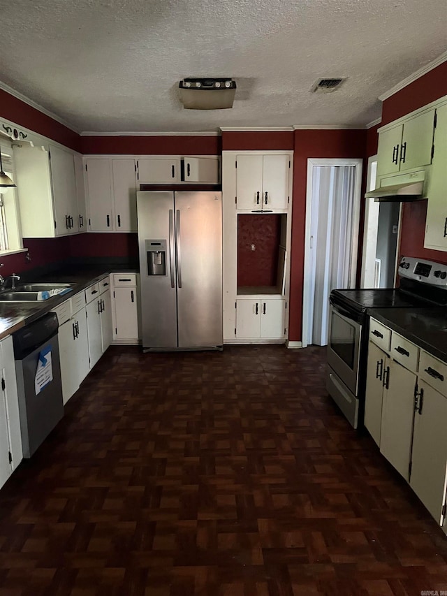 kitchen with a textured ceiling, dark parquet flooring, stainless steel appliances, and white cabinetry