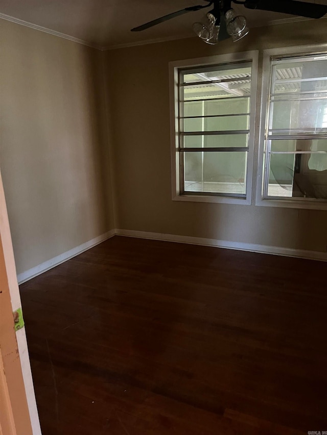 spare room featuring plenty of natural light, dark hardwood / wood-style floors, ornamental molding, and a notable chandelier