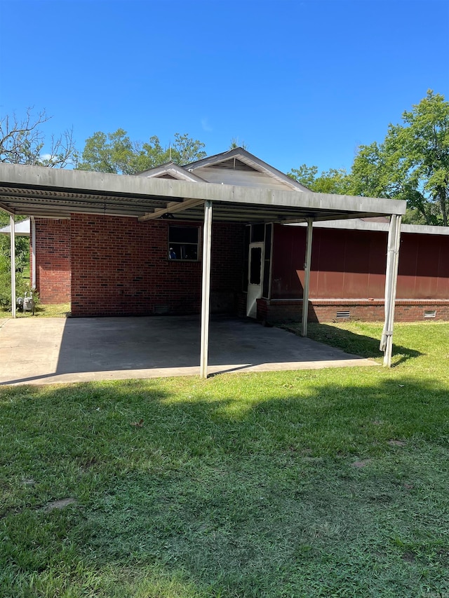 rear view of house with a lawn and a carport