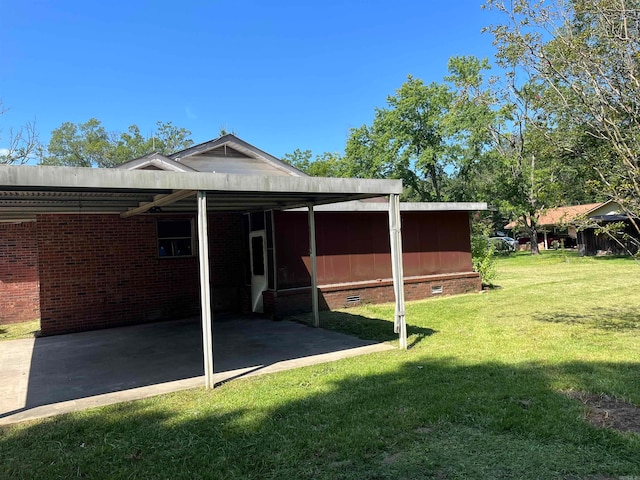 back of property featuring a carport and a lawn