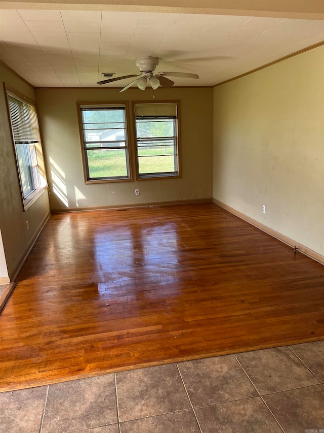 spare room featuring dark tile flooring and ceiling fan