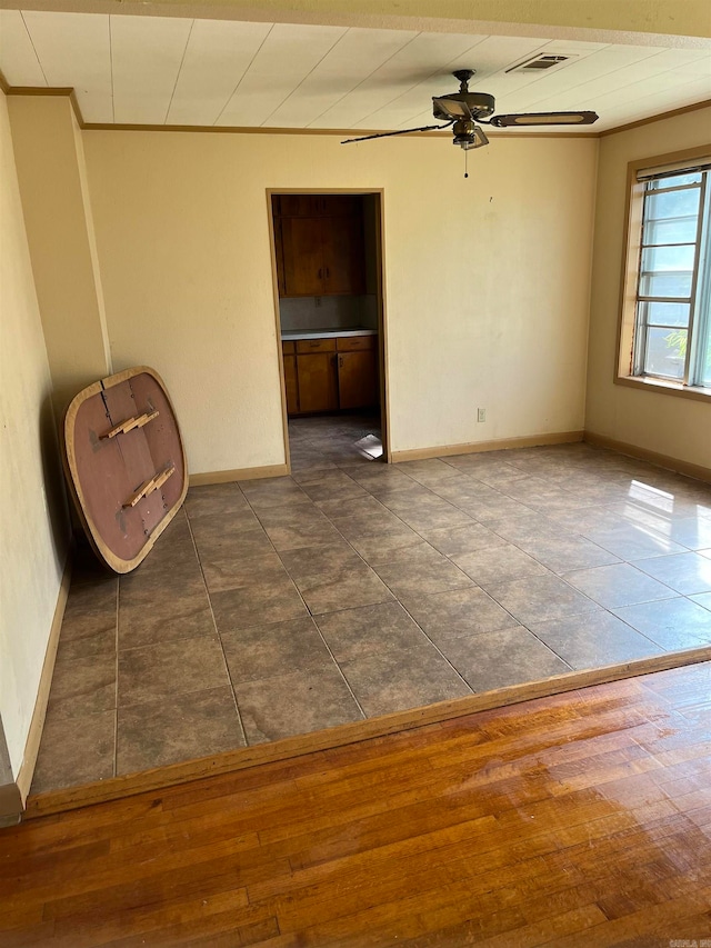 empty room featuring ceiling fan and dark tile flooring